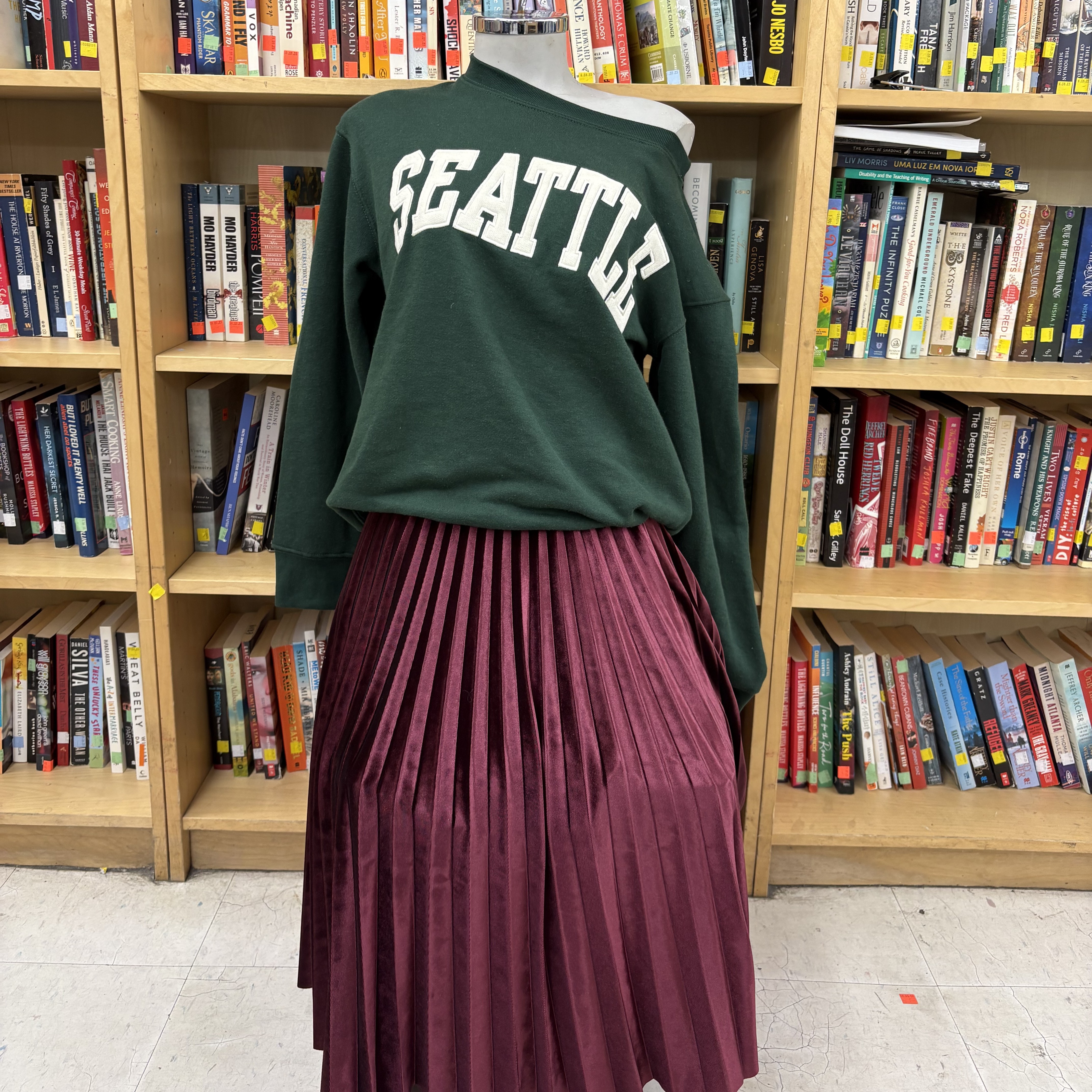 green sweater that says seattle and red pileated skirt