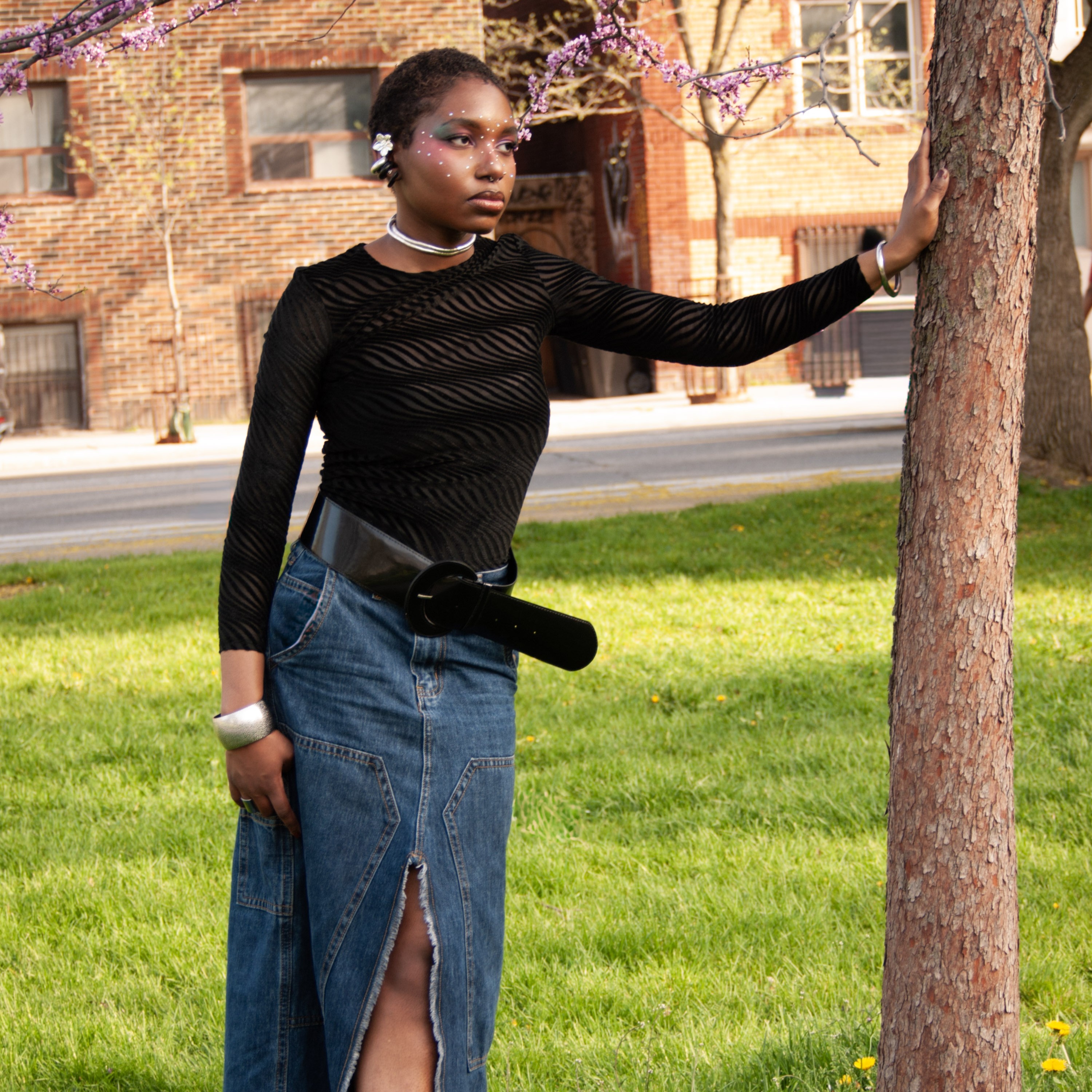 Kendra posting outside in denim skirt and black blouse