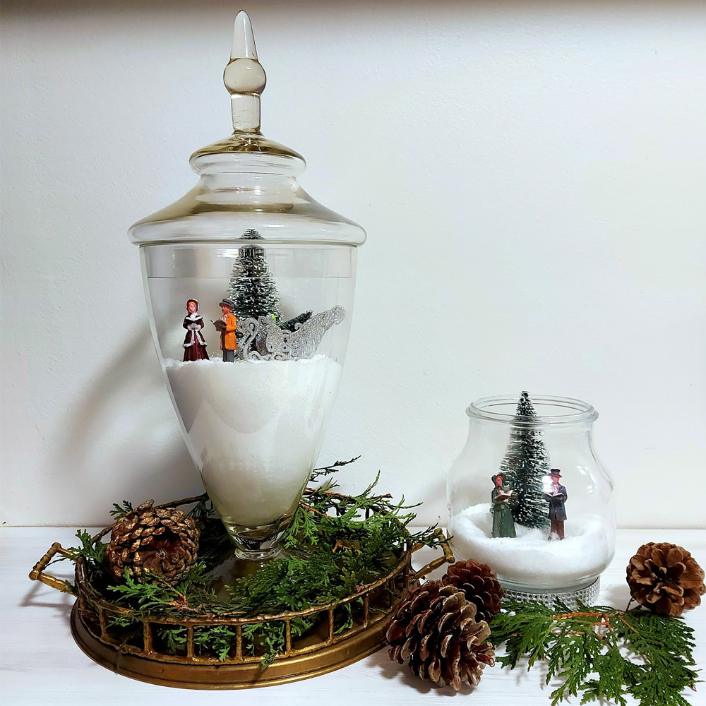 glass vase and jar with salt and christmas figurines inside